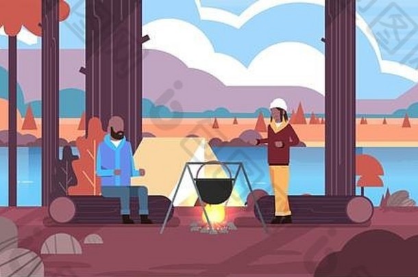 情侣徒步旅行者非洲裔美国人男女在篝火营用圆顶锅做饭帐篷露营概念秋景自然河