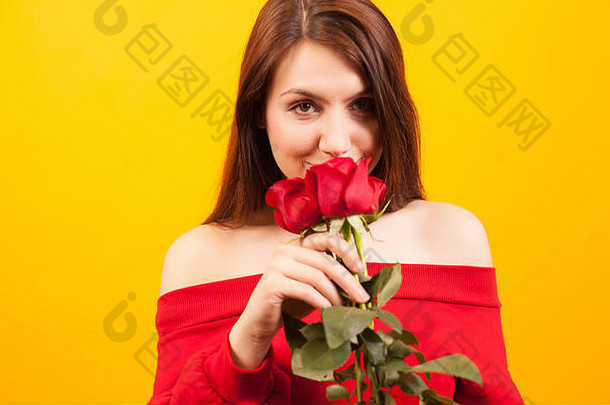 快乐的年轻的美丽的女人持有红色的玫瑰相机黄色的背景有吸引力的女人浪漫的女人