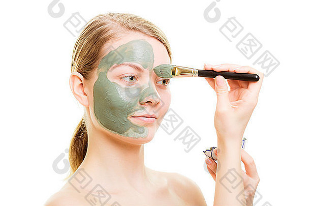 <strong>美容护肤化妆</strong>品与健康理念。年轻女子拿着刷子和碗，脸上涂着泥