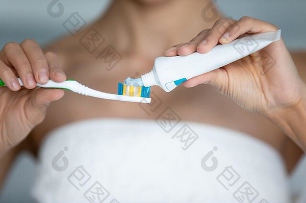 特写镜头：一位女士从牙刷管里挤牙膏