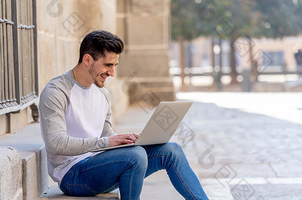 穿着休闲服的年轻迷人的新潮男子在欧洲的一家商店里学习使用笔记本电脑上网、写博客、聊天和查看电子邮件