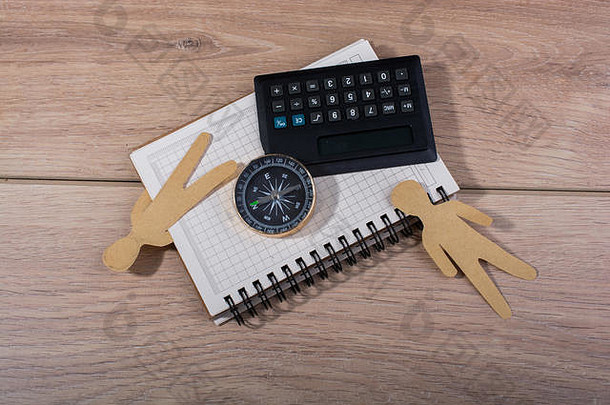 笔记本上的造纸工、指南针和计算器