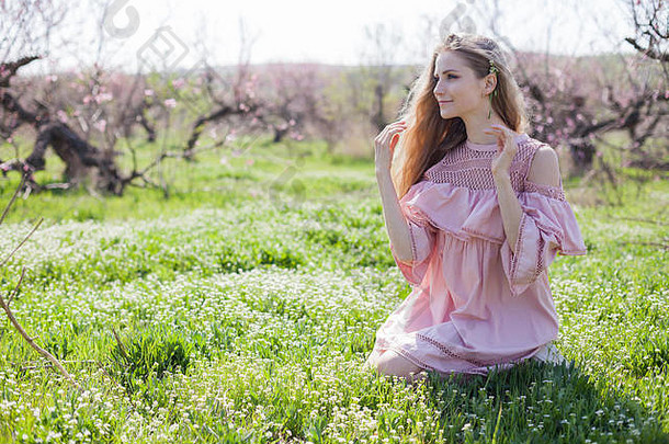 穿着粉红色衣服的金发女孩正在花园里采花