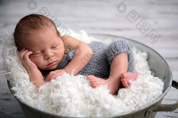 新生的，安详地睡在篮子里，穿着针织服装，冷静下来，快乐而可爱