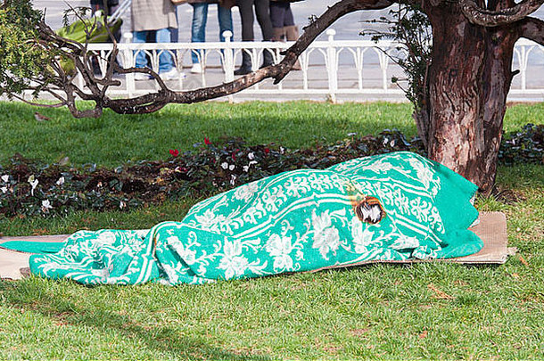 孤独的无家可归的人人睡着了毯子城市中心公园