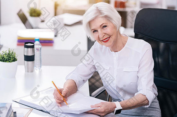 微笑着在办公室履行职责的老商务女士