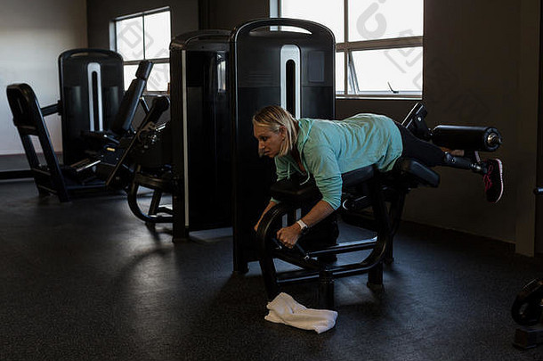 在健身房里用机器锻炼的女人