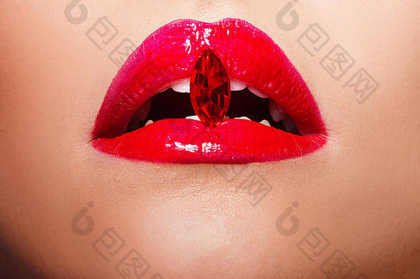 红唇上覆盖着莱茵石。嘴唇上涂着红色唇膏的美丽女人，概念化妆品