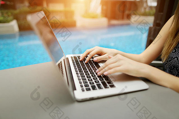 关闭女人手紧迫的键盘移动PC阳光明媚的一天游泳池