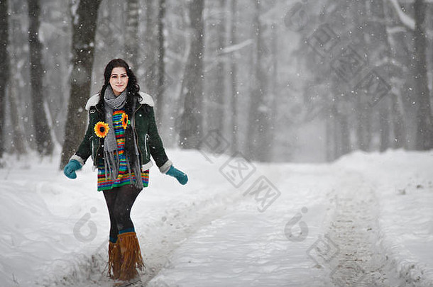 美丽的年轻的女人毛衣冬天走公园相机