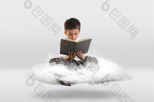 小男孩一边看书一边在云上漂浮。