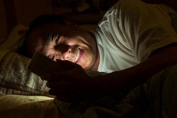 一个男人晚上在床上发短信