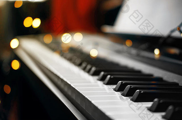背景中有漂亮的黄色灯光的钢琴键，圣诞灯的钢琴键