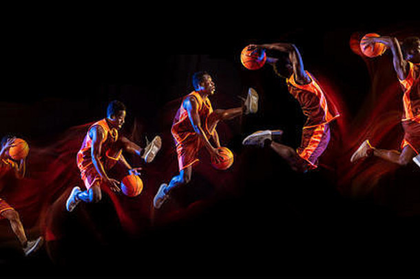 火尾巴或方式。在黑暗的演播室背景下，红队的非洲裔美国年轻篮球运动员正在比赛，霓虹灯闪烁。运动、运动、活力和健康生活方式的概念。