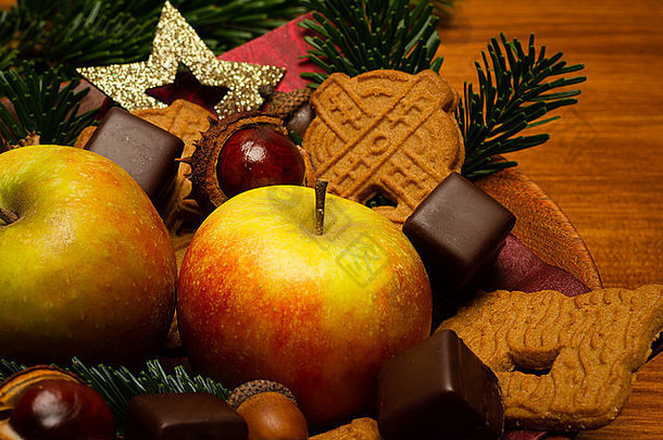 圣诞装饰用杉木、苹果、巧克力、蛋糕、星星装饰在木头上