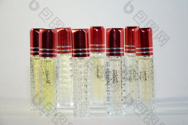 八瓶液体，由透明玻璃制成，带有红色装饰帽，放在一个圆圈中，从前视图拍摄。这幅画很漂亮