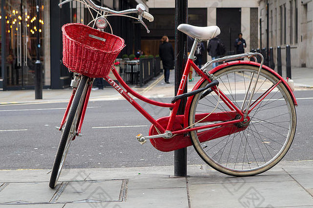 伦敦市中心，一辆优雅的女士红色自行车拴在灯柱上