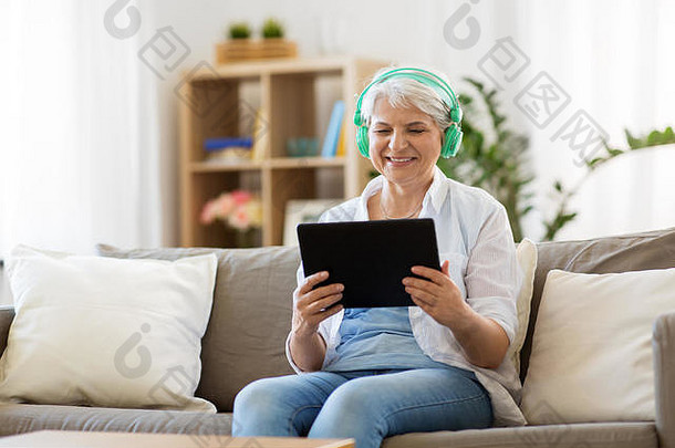 戴着耳机听音乐的老年妇女