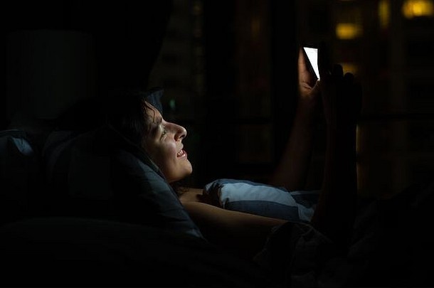 女孩床上下降睡着了智能手机检查新闻社会网络床上聪明的小工具