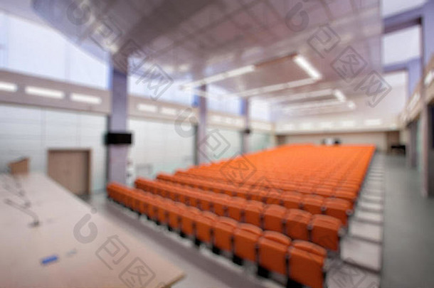 会议厅配有麦克风和电脑的抽象模糊讲台。橙色