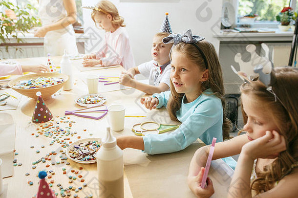 女孩的生日装饰品。餐桌上摆放着蛋糕、饮料和派对用品。