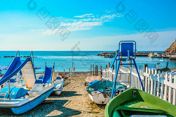 一个阳光明媚的夏日，在意大利里维埃拉的Cinque Terre，蒙特罗索阿尔马尔利古里亚海岸的沙滩上踩着小船
