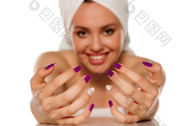 美丽的年轻的女人毛巾头显示修指甲