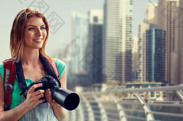 带着背包和相机的女人在迪拜城上空