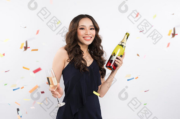 亚洲女子手持白色背景五彩纸屑酒瓶庆祝