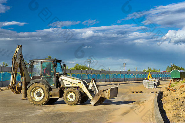 带铲斗的拖拉机进行挖掘作业。在圣彼得堡Krasnoe Selo周围修建高速绕行道路。重型机械设备