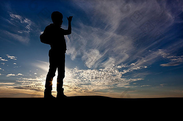 那家伙的身影在一片倾斜的美丽天空中，远远望去，一只手举在眼前
