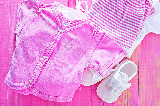 粉色桌子上的婴儿衣服，一堆婴儿衣服