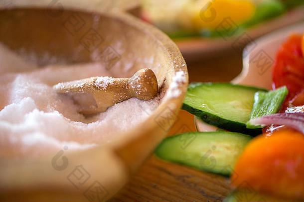 传统的用松木雕刻的盐容器，放在盛满健康切片蔬菜的盘子旁边。五彩缤纷的<strong>夏秋</strong>收获