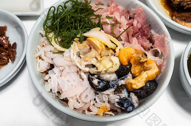<strong>韩国料理</strong>——首尔当地餐厅餐桌上的泡菜和酱油上各种海鲜和切碎的生鱼片的俯视图