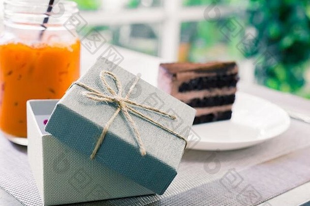 打开盘子上蛋糕和奶茶旁边的空礼品盒。它们在桌子上。度假礼物。