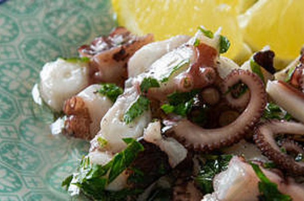章鱼沙拉的俯视图，典型的地中海食物，白色背景，黑胡椒和海盐