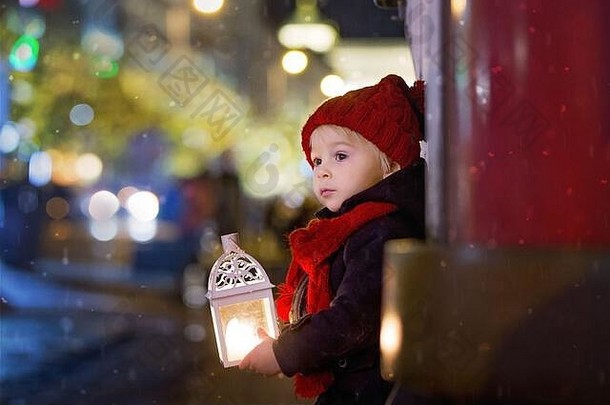 甜蜜的蹒跚学步的男孩持有灯笼泰迪熊晚上布拉格圣诞节