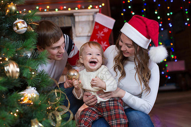 母亲、父亲和儿子在客厅装饰圣诞树