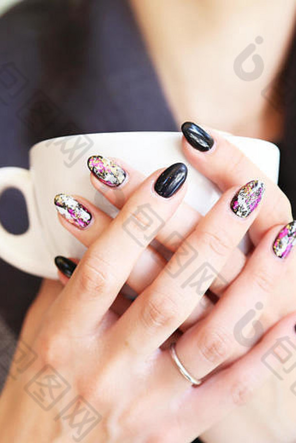 女人手美丽的修指甲持有杯咖啡黑色的波兰的设计时尚形状