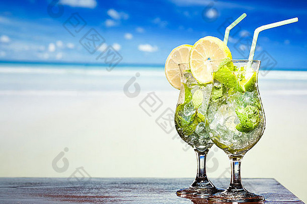 莫吉托鸡尾酒配莱姆和薄荷，海滩背景