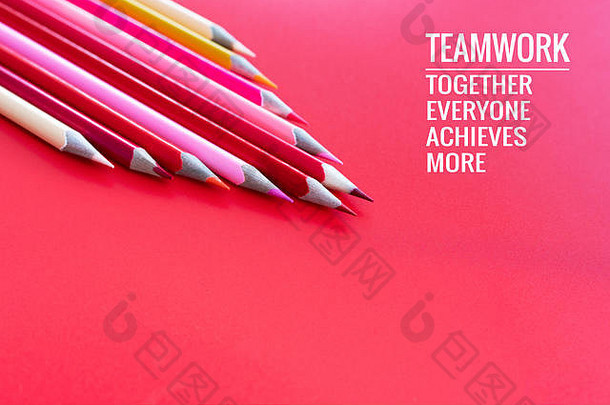 团队合作理念。粉色背景上的一组彩色铅笔，上面写着“团队合作”字样，大家在一起，成就非凡