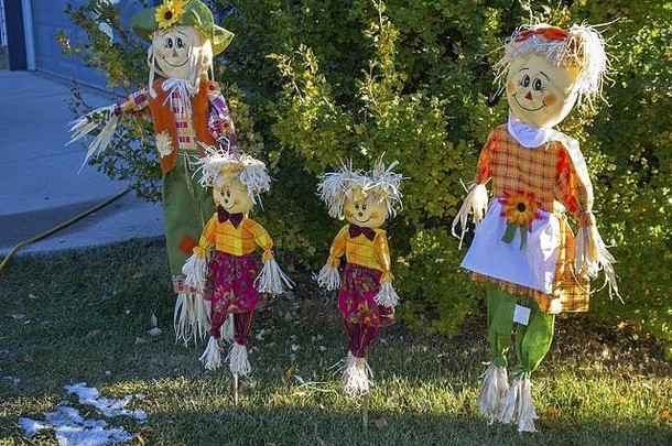 欢迎稻草人家庭在加拿大阿尔伯塔山麓住宅草坪上装饰秋季填充图案