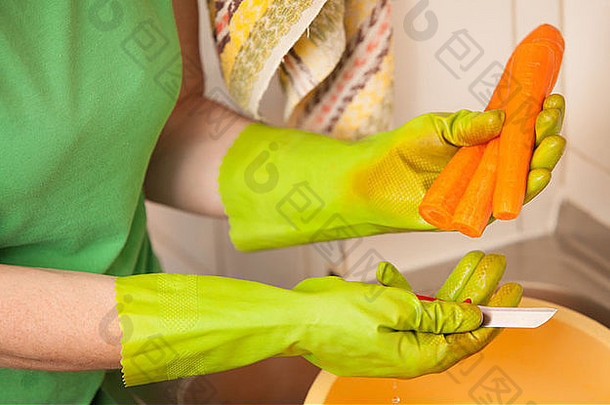 女人手绿色手套切片准备胡萝卜厨房室内健康的饮食有机营养现实的