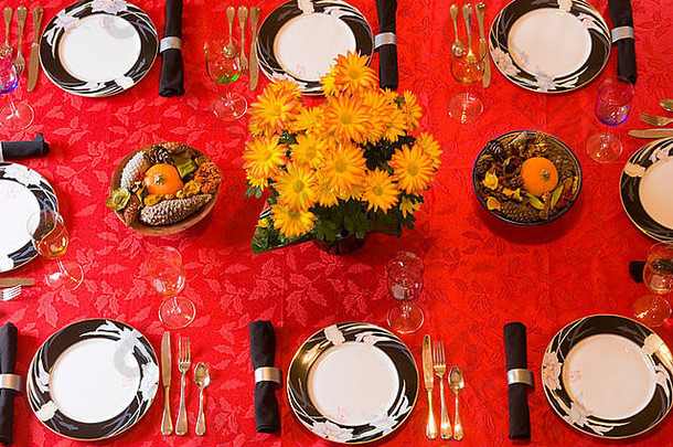 餐厅餐桌鸟瞰图用红色桌布摆放正式的中国菊花和丰收中心