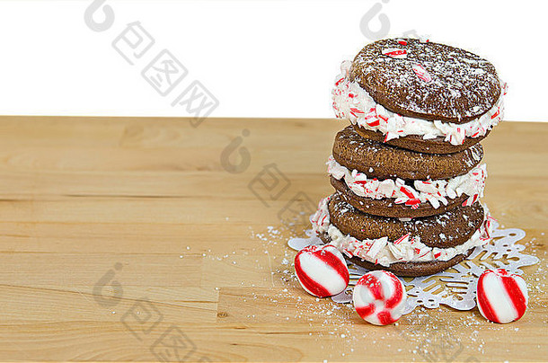 堆叠的巧克力百日咳馅饼和条纹<strong>圣诞</strong>糖果在蕾丝雪花装饰条上。