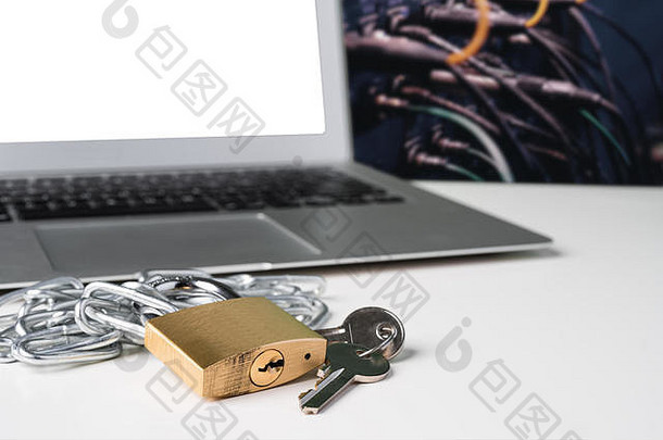 挂锁、锁链和钥匙，背景是一束电缆的笔记本电脑。网络安全抽象概念。