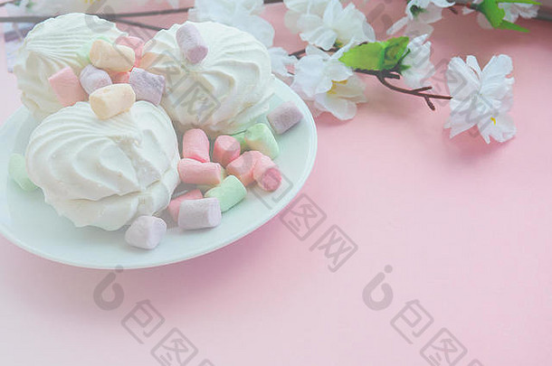 粉红色背景上白色盘子中的棉花糖