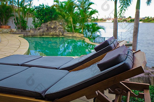 热带海滨大厦泳池边的躺椅