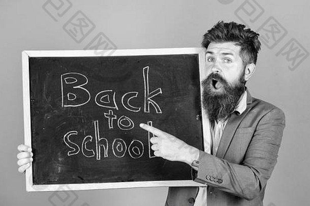 留着胡子的老师站起身来，拿着写有文字的黑板回到学校紫罗兰色的背景。继续和我们一起学习。老师邀请学生继续学习。新学期在学校。