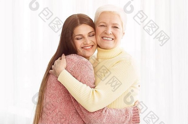 温暖的拥抱。年轻的女儿拥抱她的母亲